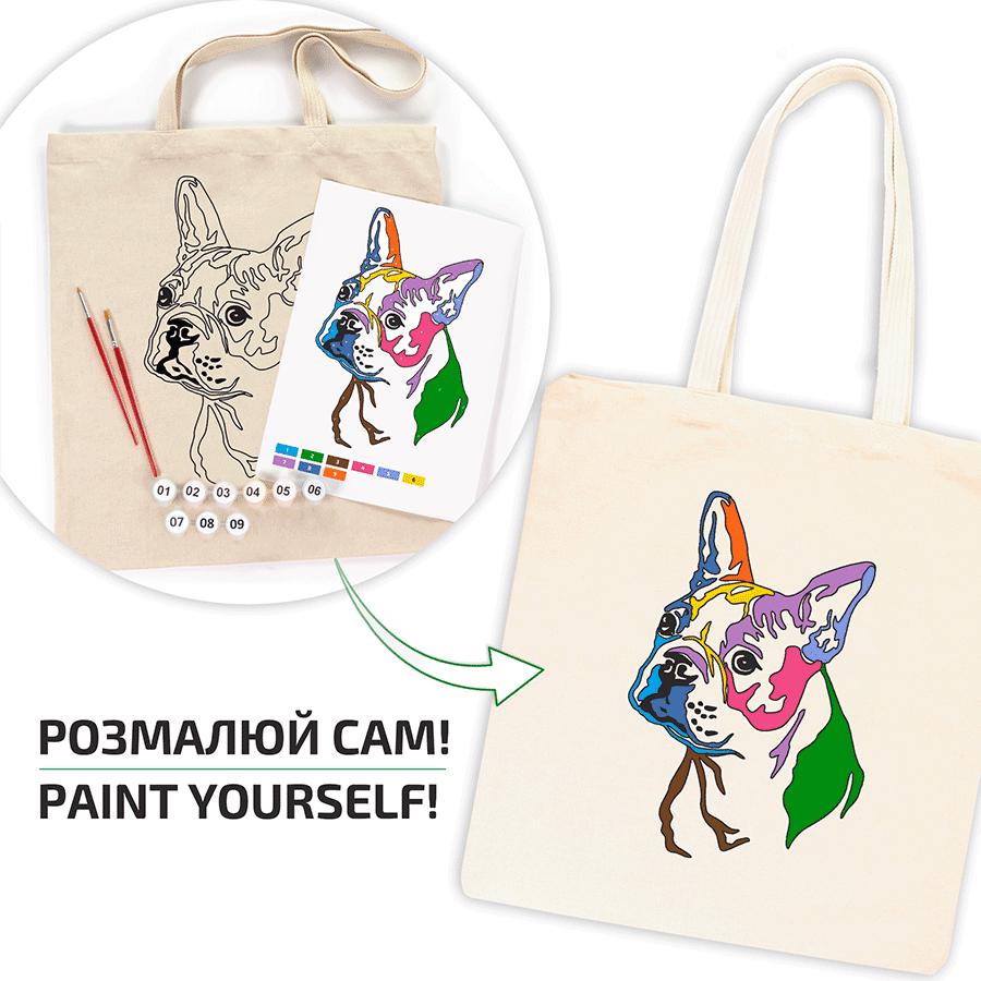 A cream-coloured tote bag featuring a colourful French bulldog design. The image shows a paint-by-numbers kit with a matching design, paintbrushes, and the text "PAINT YOURSELF!"